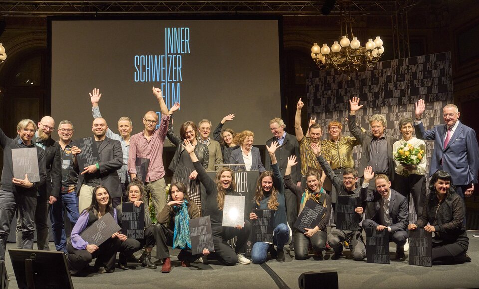 Schlussbild mit allen Beteiligten auf der Bühne im Zeugheersaal des Hotels Schweizerhof.